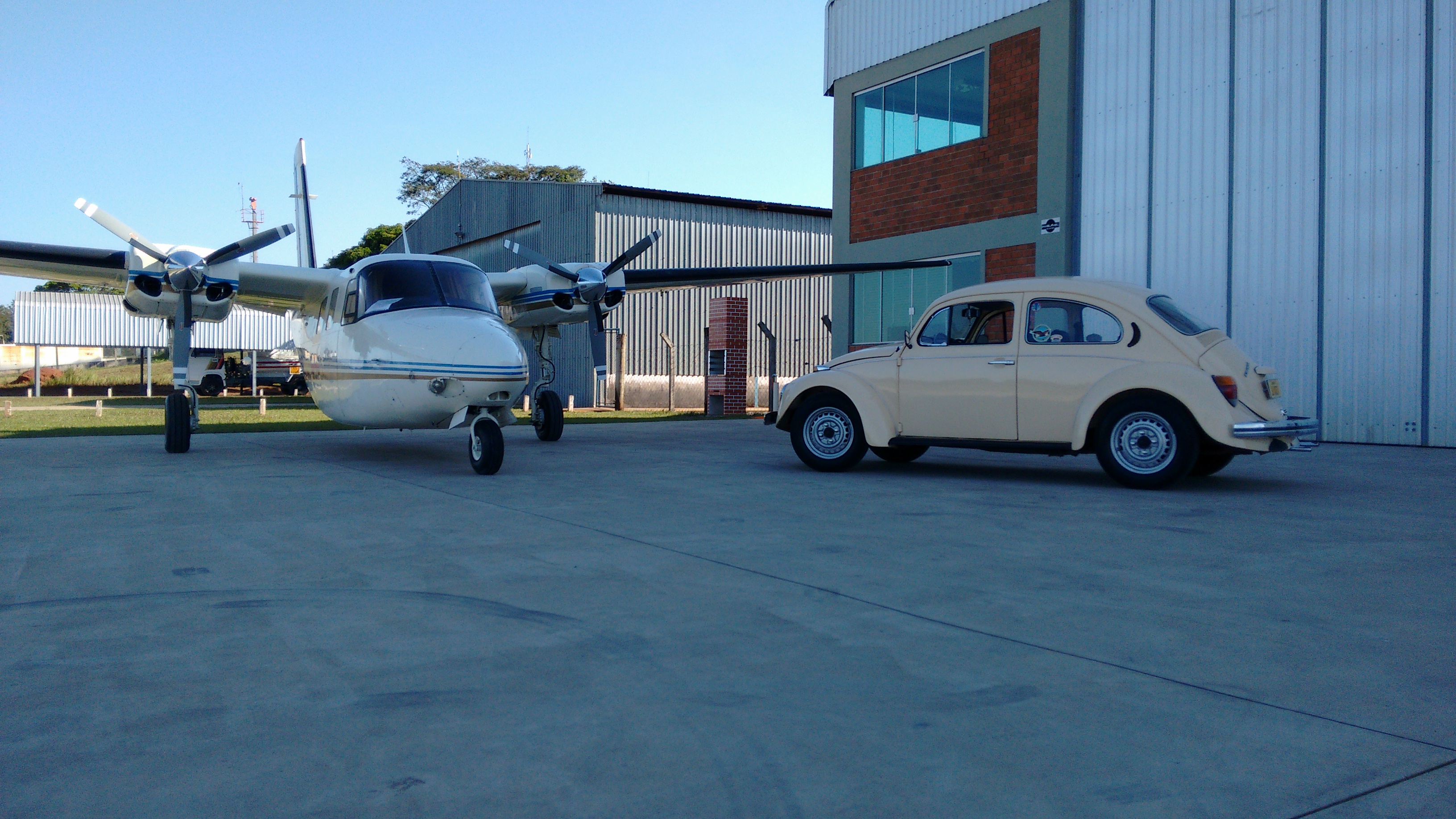 Fusca ao lado de avião antigo